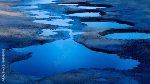 Elegant Landscape with Discrete Water Puddles Reflecting a Vibrant Spectrum of Blue Tones
