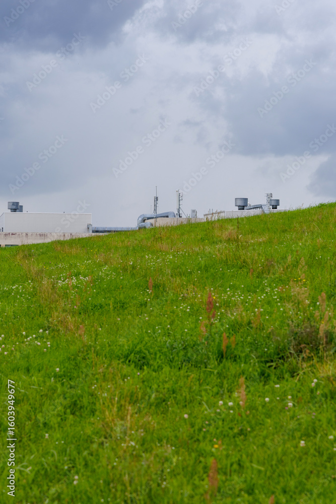 Fototapeta premium Green Hillside with Industrial Elements