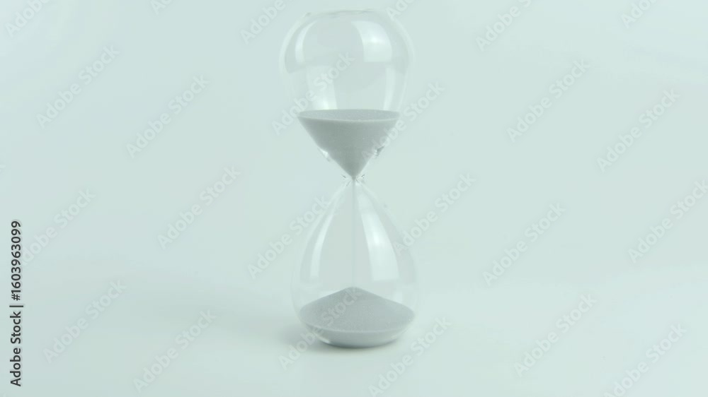 Green Technology written on a yellow sticky note placed on an hourglass. Symbolizes innovation in sustainable solutions and the role of time in environmental progress. White background