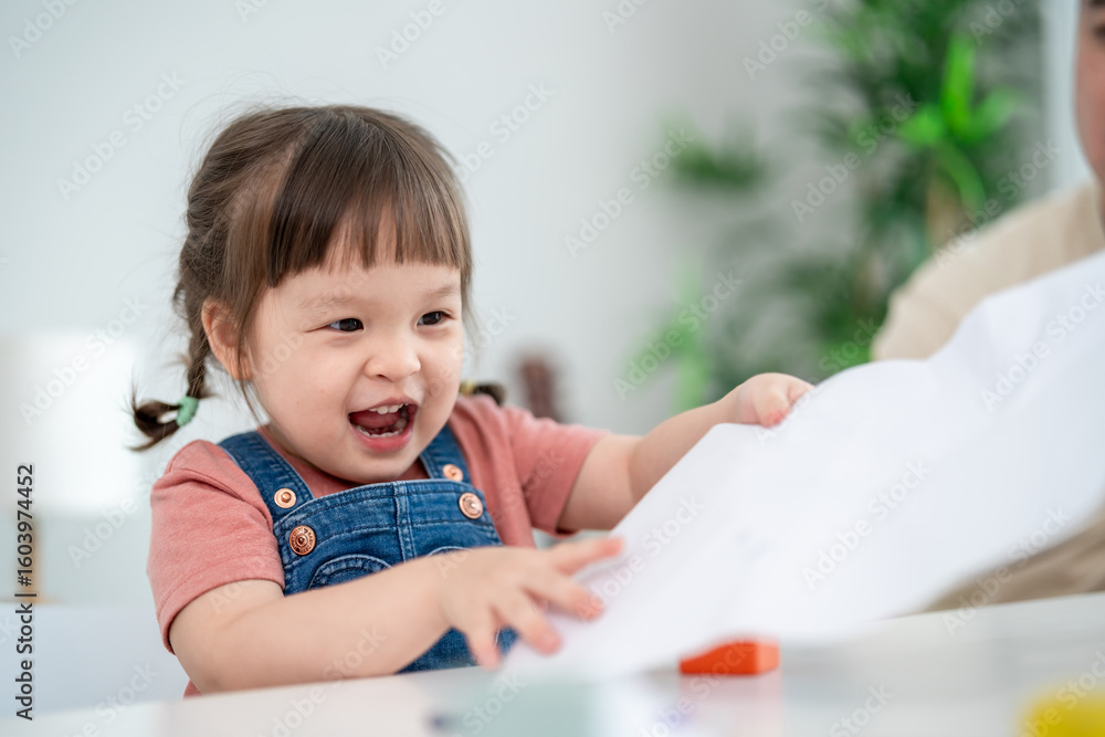 Asian young baby girl enjoy painting on paper in living room at home. Asian young baby girl enjoy painting on paper in living room at home.