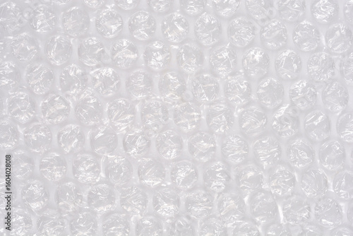 A high-angle, full-frame shot captures the textured surface of clear bubble wrap, showcasing its protective, translucent qualities as a packaging material