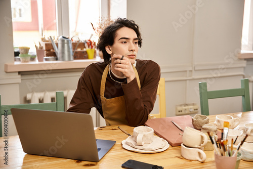 Handsome stylish man deep in thought at a pottery studio filled with creative energy