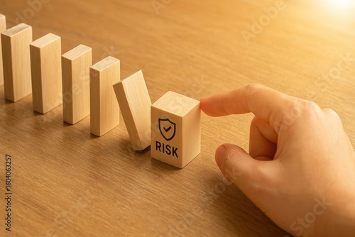 Wooden Blocks with Risk Label and Hand, Symbolizing Risk Assessment and Management in Business and Finance Settings