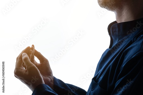 A hands raised in a gesture of prayer or supplication against a white background. Religion concept.