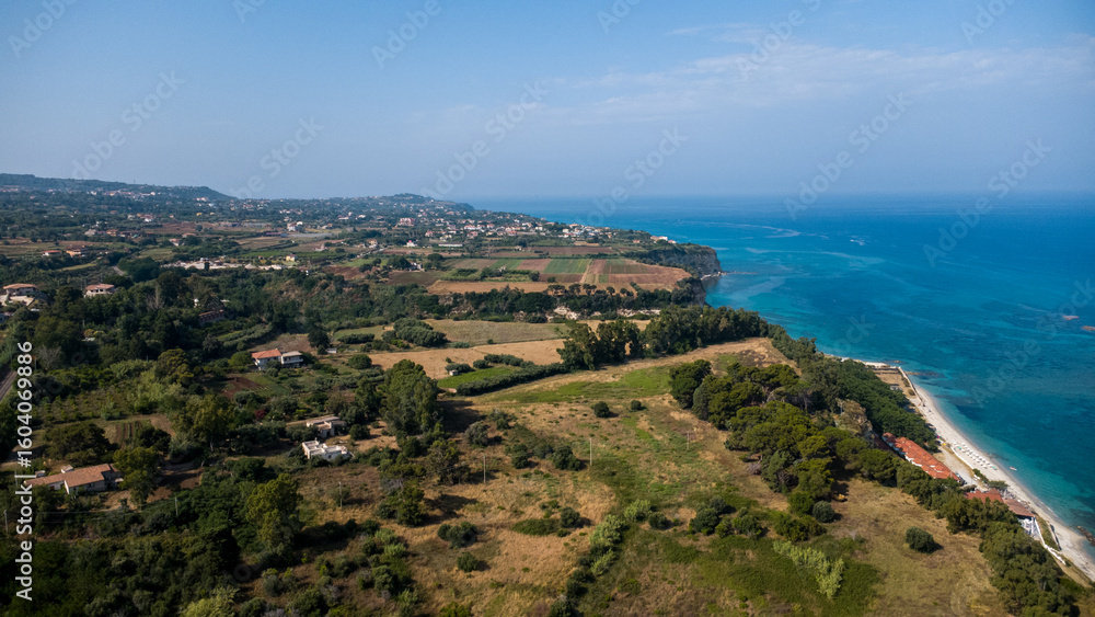 Agricultural Fields, Coastal Town, and Turquoise Sea – Aerial View of Mediterranean Landscape in Calabria, Italy Agricultural Fields, Coastal Town, and Turquoise Sea – Aerial View of Mediterranean Landscape in Calabria, Italy