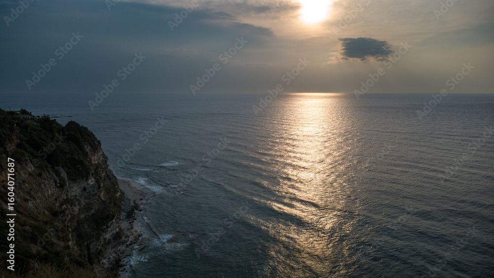 Fototapeta premium Sunset Over Cliff and Sea – Aerial View of Mediterranean Coast in Calabria, Italy