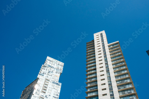 High-rise buildings against clear blue sky with vertical perspective and crisp light, excellent for themes of financial growth, innovation, urban development and real estate marketing