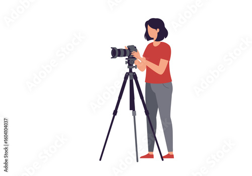 Person adjusts camera atop a tripod facing left wearing red shirt and gray pants