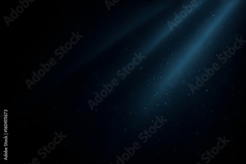 Dramatic underwater light rays penetrating deep blue water, with tiny particles creating a mysterious and serene scene.