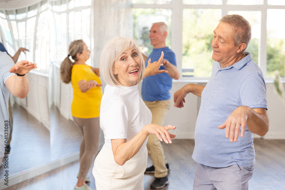 Obraz premium Couple of elderly man and elderly woman dancing twist in studio