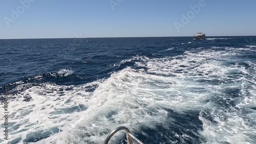 Boat tour in Kaş, Kekova and Kaleköy. Boats moving through the deep blue sea, leaving white foam behind. Antalya