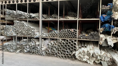 This is a plumbing supply warehouse (or 'plumbing supply store') with numerous racks of water and sewer pipes in various colors, diameters, and lengths, available for public purchase.