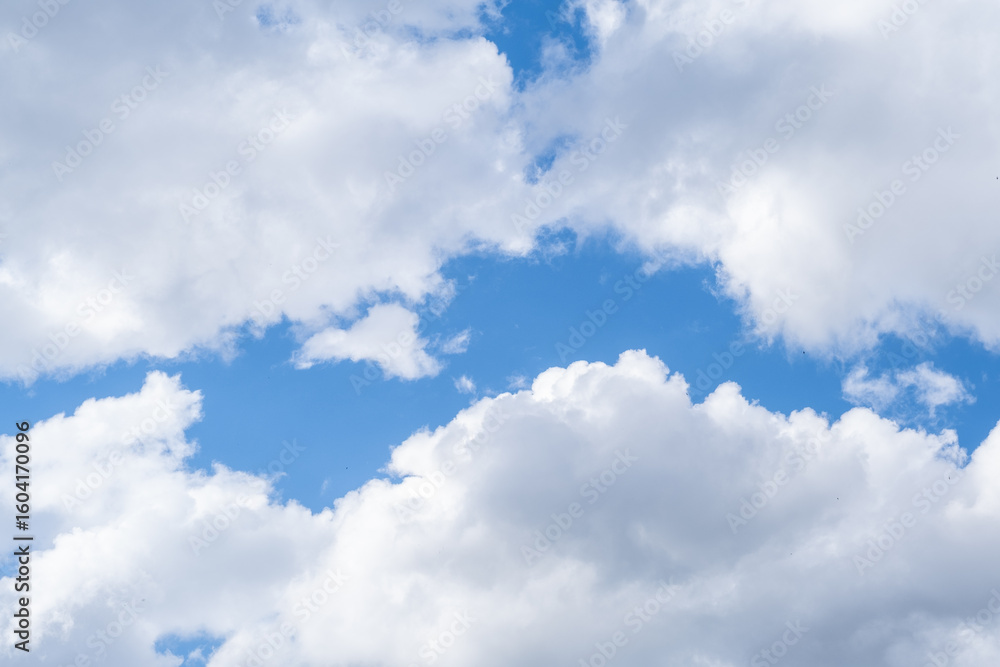 Fototapeta premium Beautiful Cumulus Clouds Floating in a Clear Blue Sky During Midday in a Serene Outdoor Setting