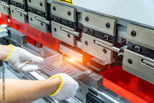 Cuadro en lienzo The technician operator working with sheet metal on CNC hydraulic press brake