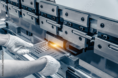Fotografía The technician operator working with sheet metal on CNC hydraulic press brake