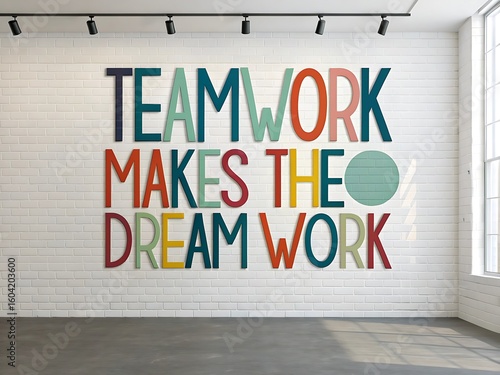 Inspirational teamwork makes the dream work quote painted on a white brick wall