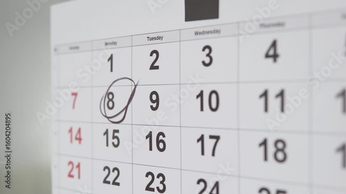 A person marks an important date on the calendar.