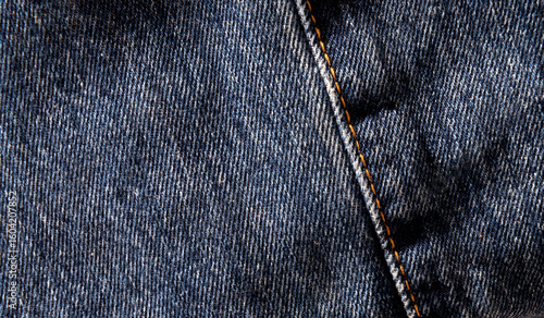 Close up  photo fabric. Denim blue with orange stitching.