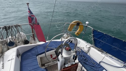 Looking aft from a sailing yacht, a Moody 336, running downwind in light airs on autopilot. Empty cockpit, just the sound of the water on the hull, the whir of the Autopilot steering the boat.