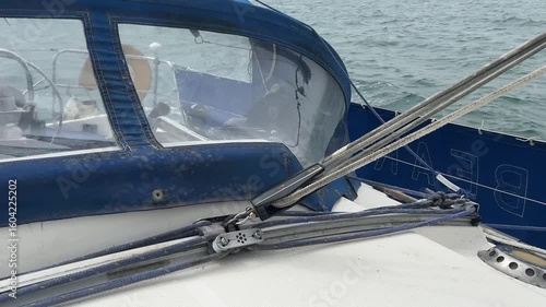 A sailing yacht main sheet and traveller controlling the mainsail as the boat runs downwind in light airs. The mainsheet is attached to the book and controls the angle of the sail to the wind