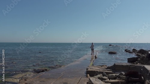 A man fishing in the sea off Peveril Ledge in Swanage, Dorset. A relaxing pastime in beautiful surroundings