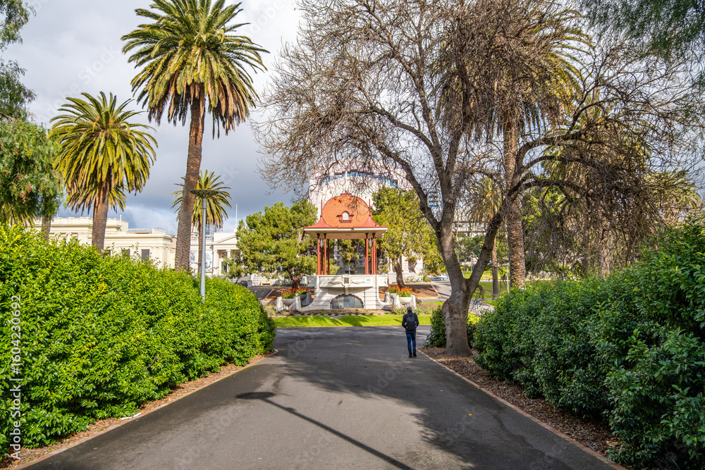 Fototapeta premium A peaceful walkway leading to the historic rotunda in Johnstone Park, Geelong, Victoria, Australia. The civic landmark and urban park is for visitors to relax and enjoy nature in the town center.