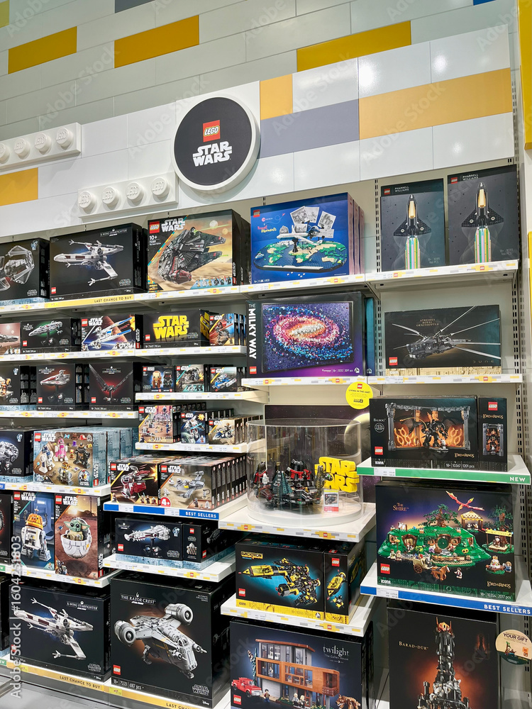 Fototapeta premium Dubai, UAE - June, 30, 2025: A vibrant display of Lego sets is arranged on shelves in a retail store. Various themed boxes, including space and city models, showcase colorful packaging.