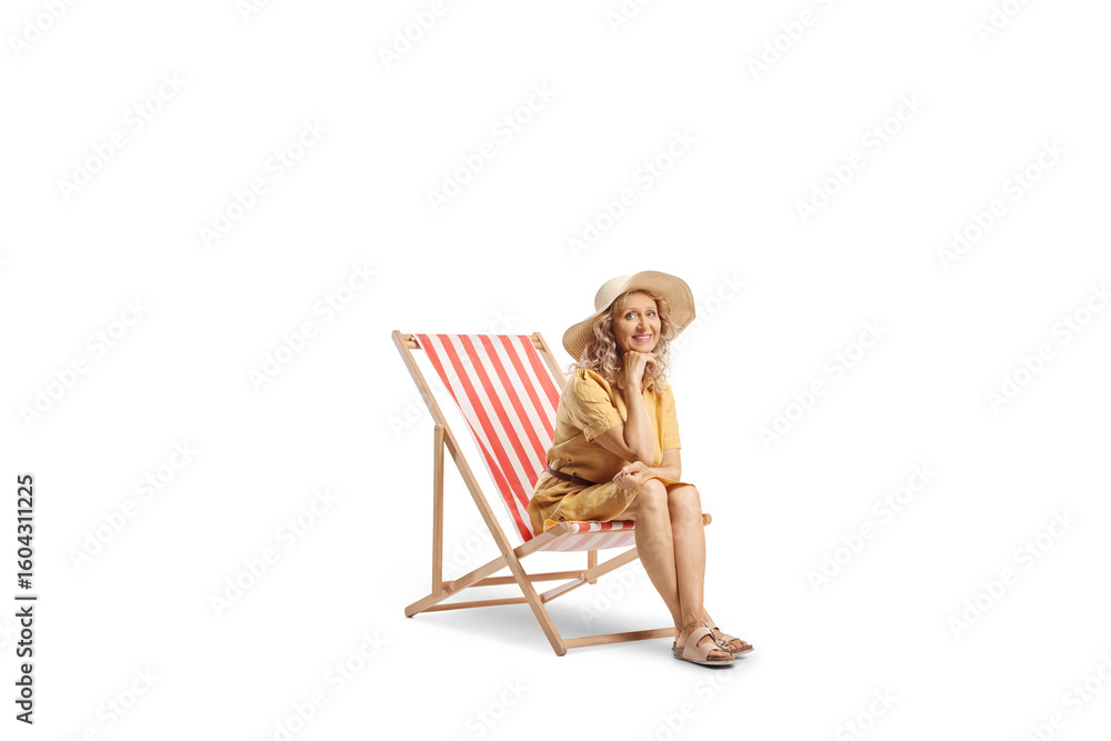 Fototapeta premium Middle aged woman sitting on a deck chair and smiling