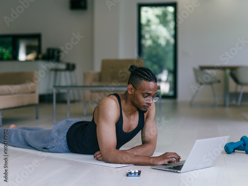African American Man Watching Fitness Video on Laptop