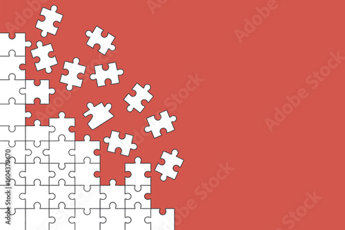 A partially completed white jigsaw puzzle on a red background with scattered pieces falling off edge