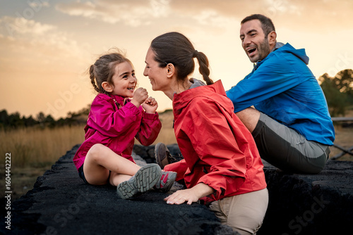 Slika na platnu A mother and daughter share a joyful, laughing moment of connection outdoors at sunset