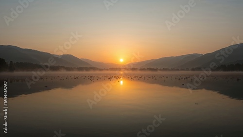 Wallpaper Mural A tranquil and dreamy scene of a misty lake at daybreak, with golden hues reflected on the still surface, encircled by dark hill silhouettes Torontodigital.ca