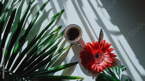Minimalist Top View Workspace: Tablet Central with Coffee Cup, Black Pen and Red Flower on White Background​

