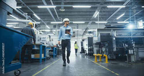 Chief Technical Officer Working at Metal Components Production Factory. Young Middle Eastern Specialist Walking in the Facility, Using Tablet Computer to Monitor the Manufacturing Process