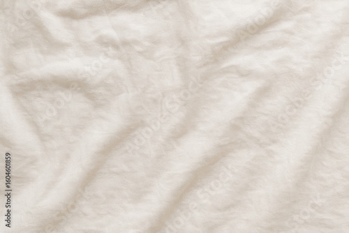 Soft beige fabric texture with natural folds and wrinkles used in clothing, textile, and decor imagery