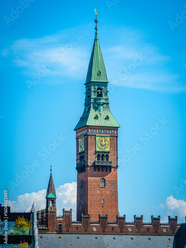 Copenhagen City Hall’s iconic clock tower rises against a vivid blue sky, blending historic architecture with Scandinavian charm—a must-see travel destination in Denmark.