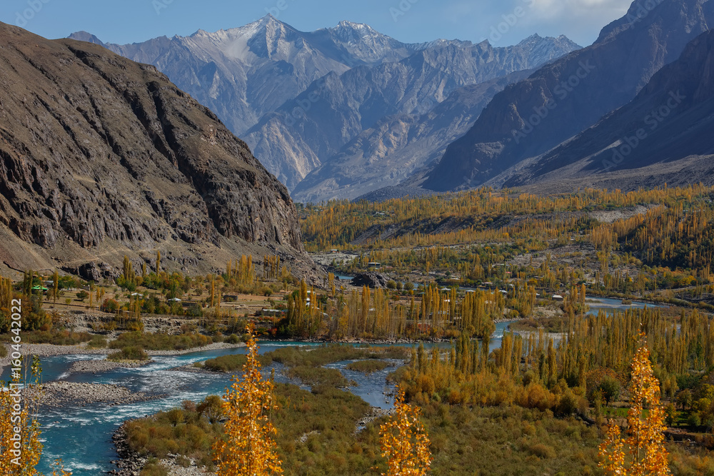 Fototapeta premium Autumn view Flowing blue water of Gilgit River with Hindu Kush mountain range in the background,Gahkuch, Pakistan.