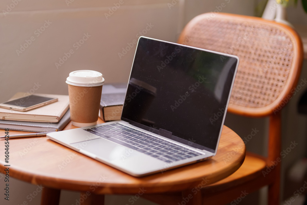 Fototapeta premium Remote work laptop home office setup with coffee and books for productive online learning or digital nomad lifestyle in a modern cozy workspace