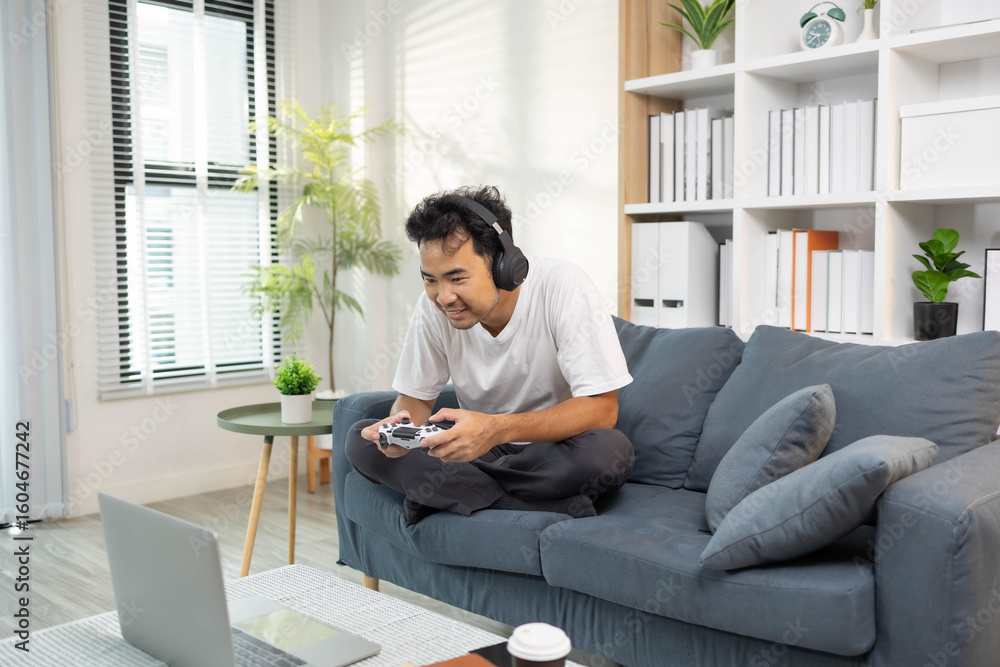 A man is playing video games on his laptop while sitting on a couch, having fun on his vacation.
A man is playing video games on his laptop while sitting on a couch, having fun on his vacation.