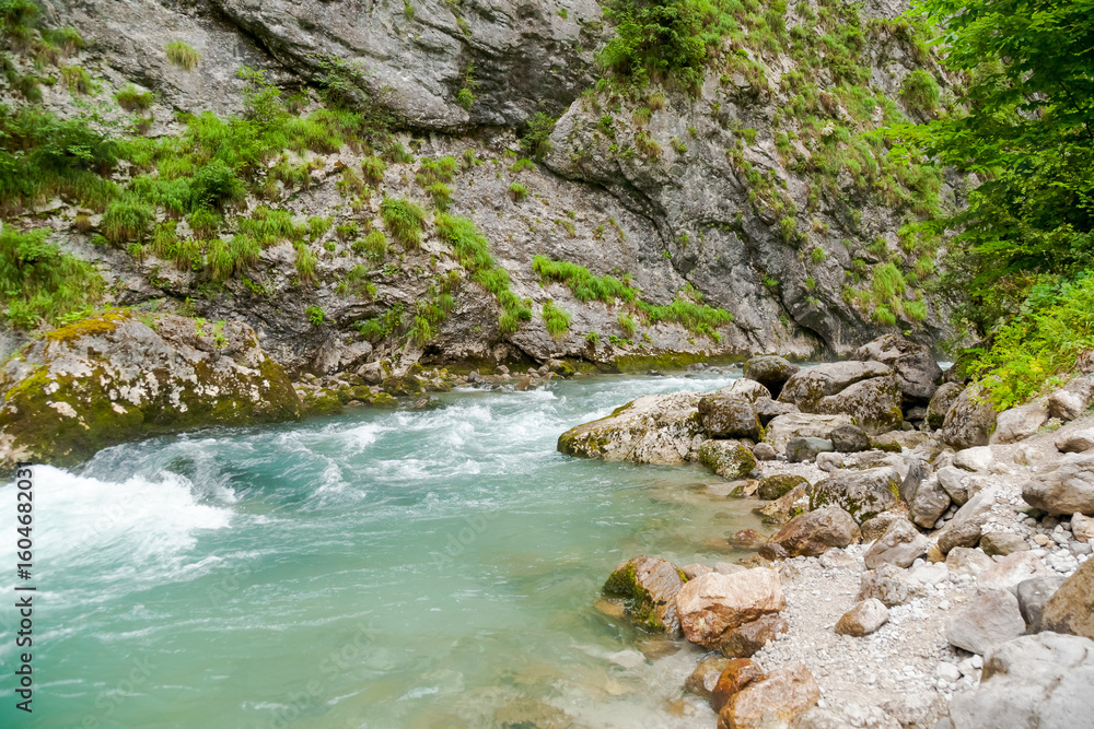 Fototapeta premium River with a green rock in the middle