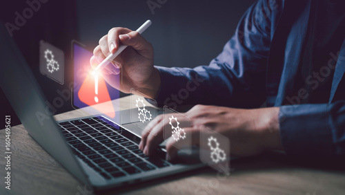 Businessman using digital pen and laptop, detecting system error with warning icon. Concept for issue detection, troubleshooting, and problem-solving in modern technology.