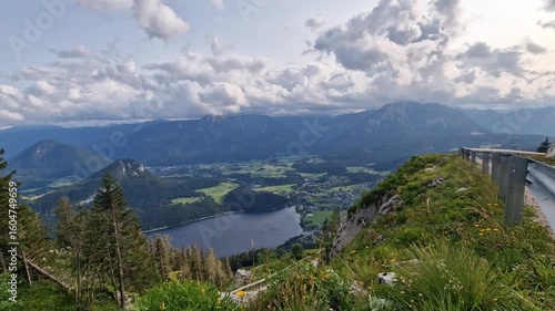 Austrian landscape in summer- hyper lapse. Aerial hyper lapse of clouds and shadows moving across a valley. The view from the Loser peak of the road, lake, and the rocky peaks with the Dachstein.