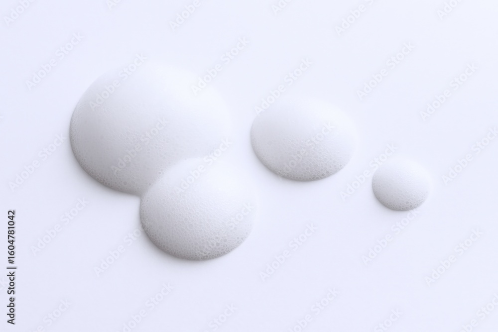 Collection of four white puffy porous foam balls of varying sizes on a white background perfect for design and craft projects Collection of four white puffy porous foam balls of varying sizes on a white background perfect for design and craft projects