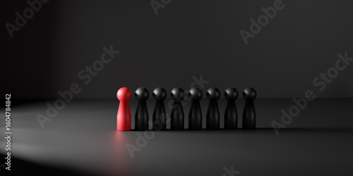 Photos Leadership is symbolized by a red doll illuminated in a spotlight among black ones
