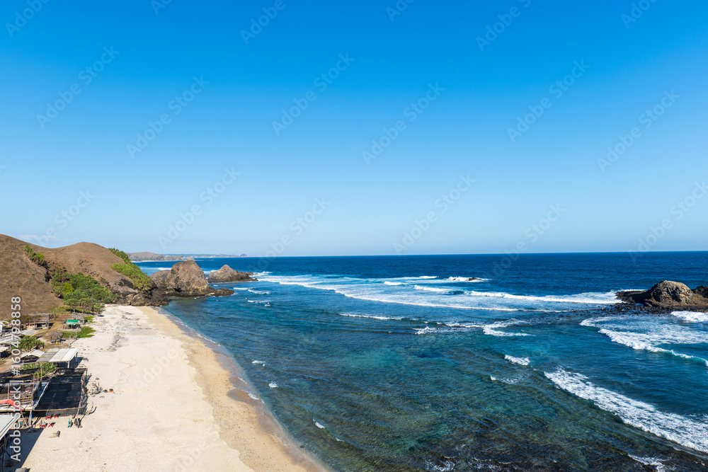 Fototapeta premium Lombok, Indonesia, Beach ocean sunset drone aerial view landscape at Seger beach area. Lombok is an island in West Nusa Tenggara province, Indonesia.