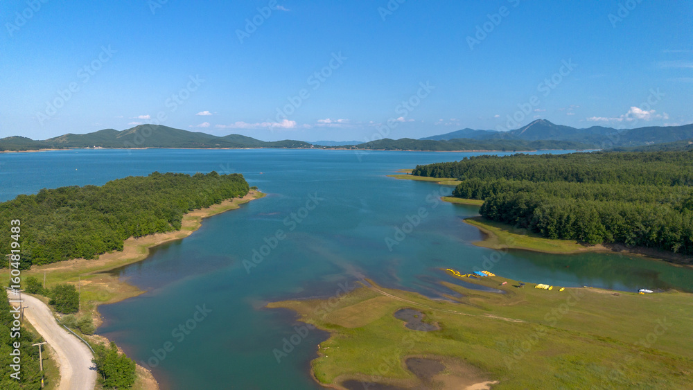 Fototapeta premium Plastiras Dam, an arch dam in the Karditsa regional union of Greece, which flows into the Tavropos River, forming the artificial Plastiras lake.