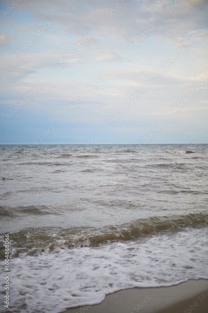 Calm sea under cloudy sky at sunset time Calm sea under cloudy sky at sunset time