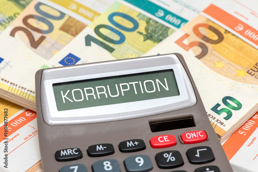 Das Display von einem Taschenrechner ist beschriftet mit Korruption und steht über vielen Euro Banknoten Das Display von einem Taschenrechner ist beschriftet mit Korruption und steht über vielen Euro Banknoten