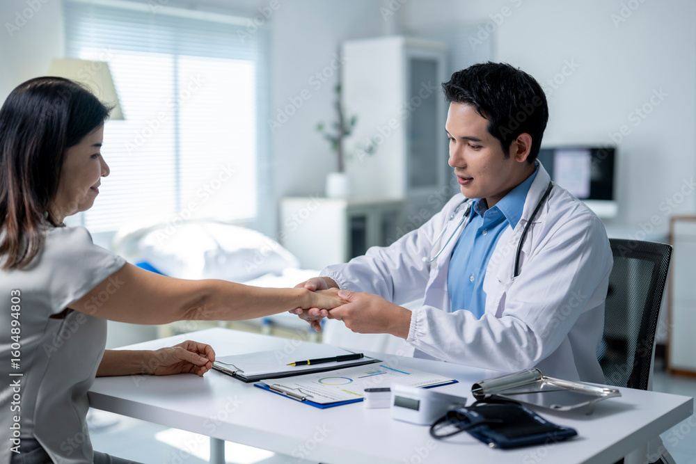 Obraz premium A man and a woman are sitting at a desk in a hospital room