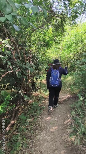 a group of people hiking on a trail through a lush green forest and up a steep slope: Kediri, Indonesia-July, 24 2025
